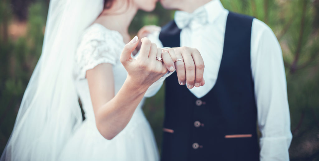 newlyweds intertwining pinkies