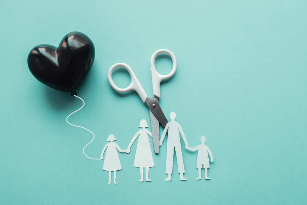 scissors cutting family paper cut out holding black heart