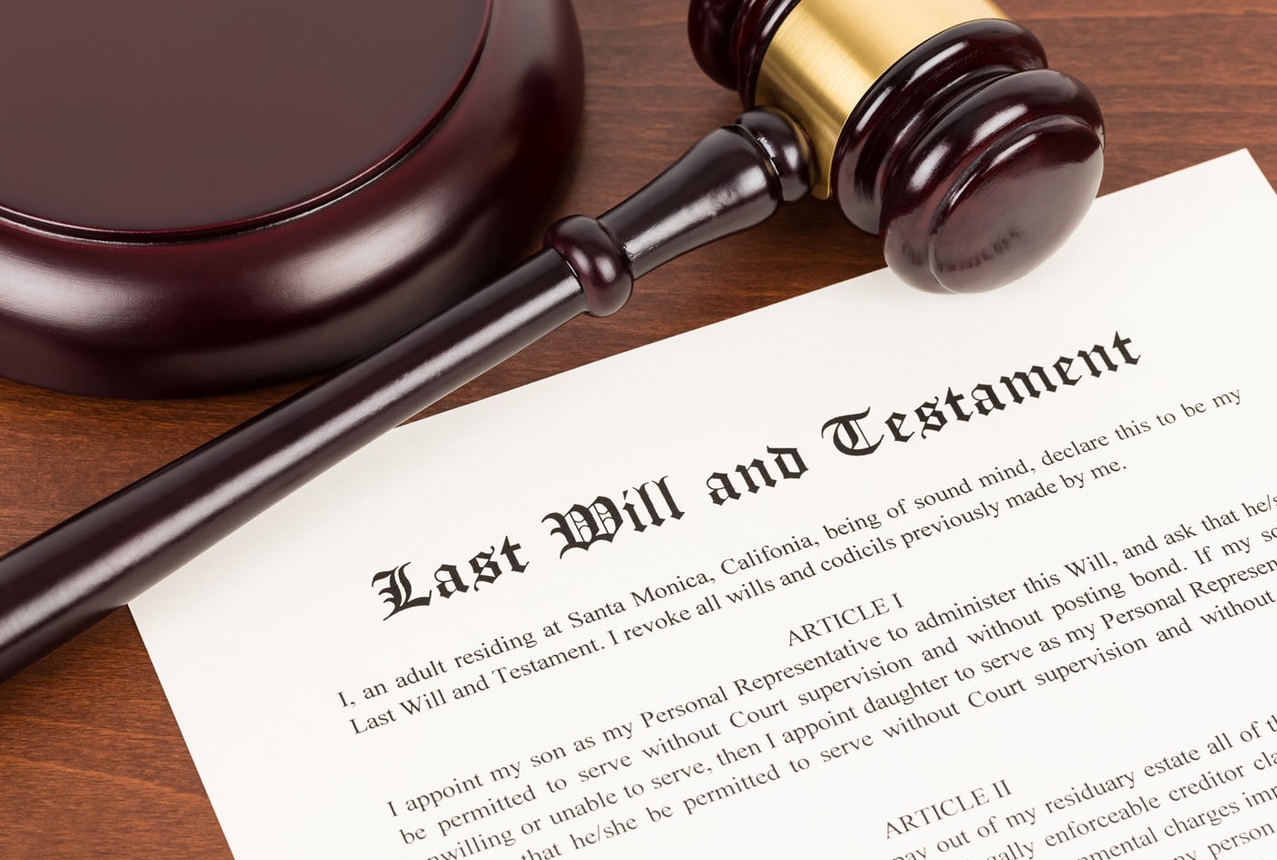 Last will and testament on yellowish paper with wooden judge gavel; document is mock-up